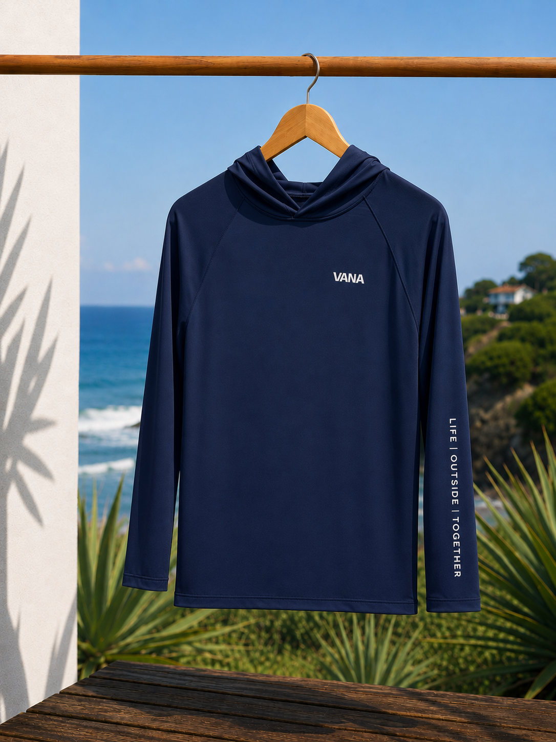 VANA navy sun shirt on hanger by the coast