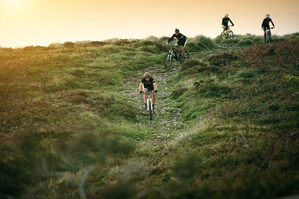 Cyclists riding the coastal trails at golden hour